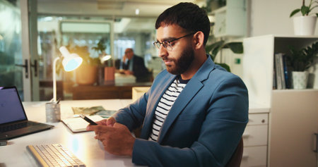 Mobile, night and business man in office for financial coverage, sales or client quote. Phone, overtime and worker networking, communication or insurance broker typing on chat app for policy reviewの写真素材