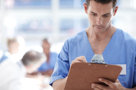 Man, doctor and writing on clipboard at clinic for schedule update, healthcare agenda and appointment. Male person, document and checklist with medical results, patient diagnosis and treatment scriptの写真素材