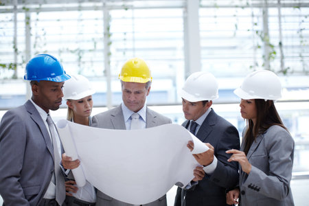 Business people, architects and blueprint planning at construction site, teamwork and meeting. Employees, paperwork and logistics for floor plan of development, engineering project and renovationの写真素材