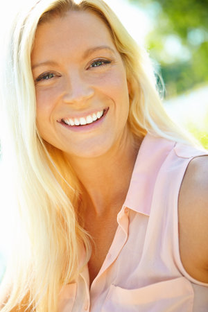 Woman, portrait and smile in nature for relax, stress free and positivity in Australia. Girl, happy face or outdoor in sunshine for travel, fresh air or summer vacation with me time for mental healthの写真素材
