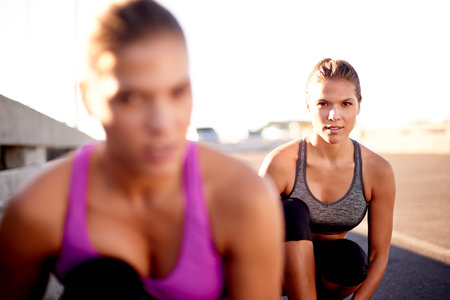 Women, start and race in city for fitness, ready and competitive on bridge. Friends, portrait and runners in urban Portugal for cardio, training support and outdoor for sports challenge or wellnessの写真素材