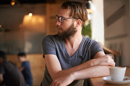 Thinking, relax and drink with man in coffee shop for reflection, idea and lunch break. Memory, decision and future with male customer in cafeteria for inspiration, restaurant opportunity or solutionの写真素材