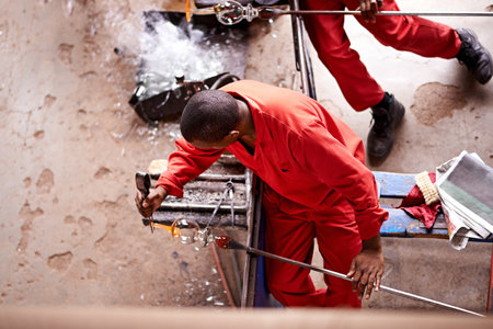 Glassblowers, vase and man in workshop with heating equipment, professional craft and production. Manual, factory or top view of person molding object with tools for labor, manufacturing and shapeの写真素材