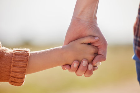 Agriculture, holding hands and walking with family on farm together for conservation or sustainability. Safety, security or trust with parent and child outdoor in countryside for guiding or leadingの写真素材
