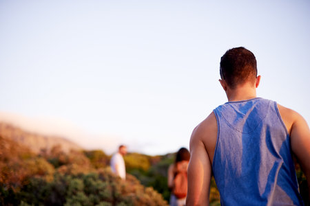 Man, back and hike on mountain for countryside, travel or adventure to explore nature. Journey, group of friends and vacation with natural environment for walking, fitness hobby or bonding togetherの写真素材