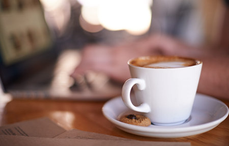 Coffee, person and relax in restaurant for hospitality, service and laptop for remote work. Mug,...