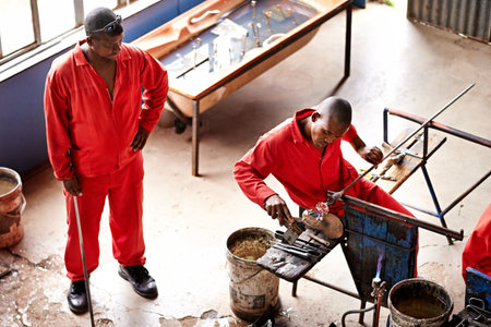 Glassblowers, vase shape and man in workshop with equipment, professional craft and production. Industrial, factory or top view of artisan molding object with tools for manual labor or manufacturingの写真素材
