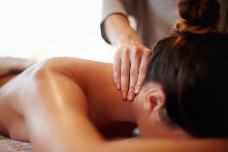 Woman, hands or relax with neck massage at spa for physical therapy or body treatment at resort. Closeup, masseuse or female person lying on bed at luxury salon for shoulder rub, zen or stress reliefの写真素材