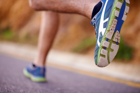 Running, fitness and shoes of man in street for exercise, training and race for workout. Closeup, sports and feet of person for wellness, health and active for performance, challenge and marathonの写真素材
