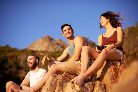 Friends, view and hike break on mountain for countryside, travel or adventure to explore nature. Trekking, group of people and journey for natural environment hiker, hobby and bonding togetherの写真素材