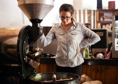Coffee machine, roast and service with barista woman in kitchen of cafe for brewing or hospitality. Caffeine, equipment and process with waitress in restaurant for retail sale of fresh beverageの写真素材