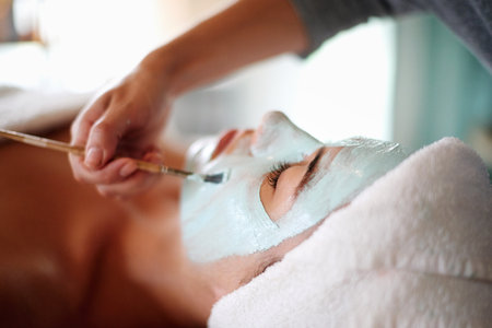 Skincare, beauty and woman with facial mask in spa for treatment, wellness and healthy skin. Dermatology, luxury salon and person with beautician with clay for anti aging detox, cosmetics and cleanseの写真素材