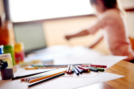 Art, paper and pencils with child in bedroom of home for creative development or picture drawing. Desk, homework and stationery with student in apartment for academic growth or school learningの写真素材