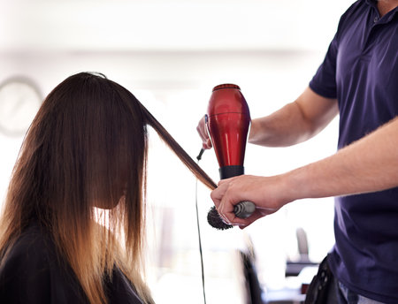 Hair care, dryer and hairdresser with woman in salon for volume, protein and deep conditioning treatment. Cosmetic, equipment and stylist with female client for blow out hairstyle in beauty parlor.の写真素材