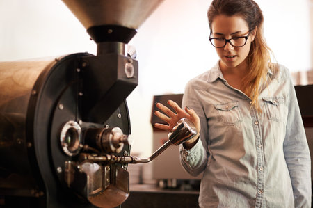 Coffee machine, process and roast with barista woman in kitchen of cafe for brewing or hospitality. Caffeine, equipment and service with waitress in restaurant for retail sale of fresh beverageの写真素材