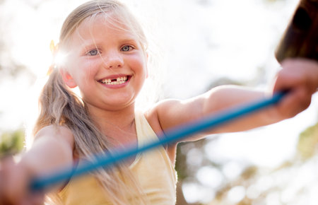 Happy girl, portrait and fun childhood with playground at outdoor park for playful summer in nature. Cute child, young kid or toddler with smile or youth for weekend, holiday or playing in sunshineの写真素材