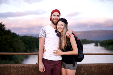 Portrait, happy couple and hiking by lake for travel, adventure or journey on holiday for date by mountain. Man, woman and trekking together by river outdoor for tourism, vacation and hug in Portugalの写真素材