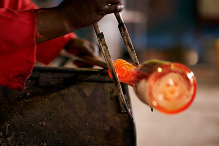 Person, hands and glass in workshop for production, manufacturing or creativity in small business. Craftsman, tools or skill in startup factory for bespoke ornaments, design process or shaping methodの写真素材