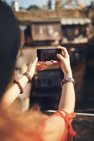 Travel, phone screen and girl in city with memory, buildings and outdoor adventure on summer holiday. Digital photography, tourism and influencer woman on urban vacation with social media live streamの写真素材