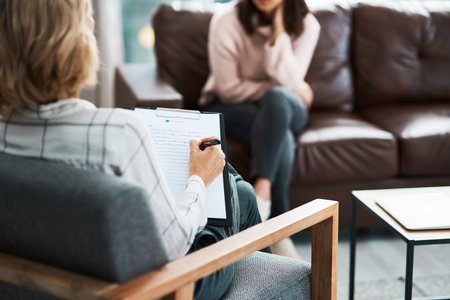 Woman, therapist and clipboard for counselling, help and writing with support on couch. Psychotherapist notes, checklist and advise for stress, anxiety or depression for mental health consultationの写真素材