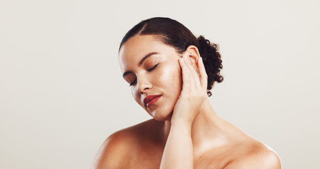 Woman, pride and beauty with makeup in studio of aesthetic, facial cosmetics or treatment glow. Female person, eyes closed and dermatology results, red lipstick and transformation on white backgroundの写真素材