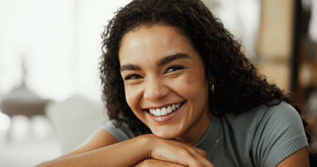 Portrait, chilling and woman with smile, home and comfortable on couch in lounge, weekend and relax. Happy, peaceful and person in living room for rest, confident or girl on break, cheerful or Canadaの写真素材