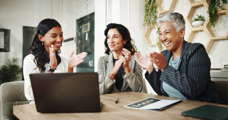 Business women, applause and video presentation with laptop, budget and financial advisor for customer portfolio. Celebration, accountant or agent meeting for teamwork, success and online promotionの写真素材