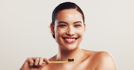 Happy woman, portrait and bamboo with toothbrush for dental hygiene on a white studio background. Face, female person or model with smile or teeth for fresh breath, oral or mouth care on mockup spaceの写真素材