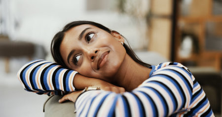 Thinking, calm and woman in home, daydreaming and planning for college in apartment, living room or peace. Lounge, contemplating and Indian person with nostalgia, smile or university student in houseの写真素材