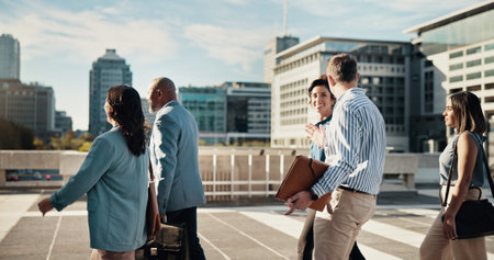 Teamwork, walking and business people in city in discussion on morning commute, travel and journey. Corporate, professional and men and women in town talking for collaboration, meeting and careerの写真素材