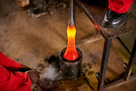 Molten, glass and mold with glassblower, craftsman and artist for creative handicraft and forming decoration. Factory, people and production with industry, equipment and process for fragile baubleの写真素材