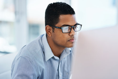Desktop, research and businessman in office for online investment proposal for company finance. Reading, technology and male financial manager with email for stock market revenue report in workplaceの写真素材