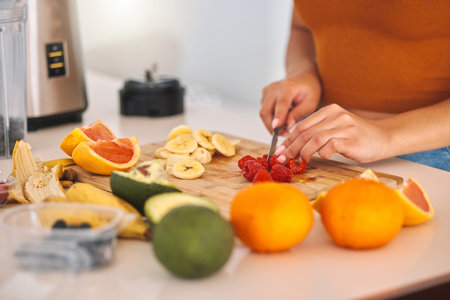 Hands, cutting and woman with fruit, blender and nutrition with diet plan, prepare snack and...
