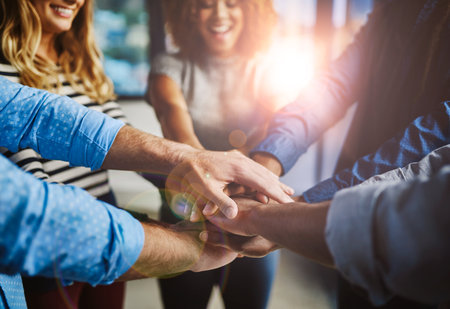 Hands, group and stack at office with support, solidarity or goals with diversity at media company. Business people, teamwork and circle with synergy, link and happy for motivation at creative agencyの写真素材