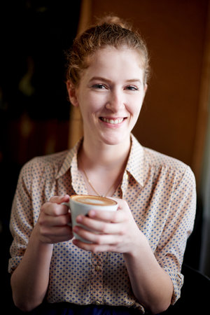 Morning, smile and portrait of woman in coffee shop with drink, caffeine beverage and cappuccino. Cafeteria, restaurant and happy person with cup for latte, espresso and tea for breakfast serviceの写真素材