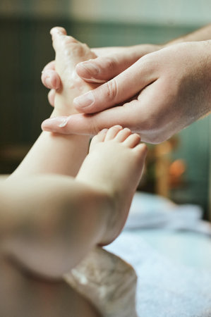 Massage, cream and feet of baby with mother for clean, dermatology and hygiene. Skincare, protection and lotion treatment with hands of mom and child in family home for cleansing, moisturizer or careの写真素材