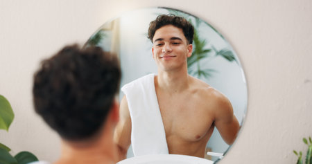 Man, confident or mirror for body in home with results, face reflection and grooming in morning. Good mood, facial glow and male person in house bathroom with proud smile, towel and skincare hygieneの写真素材