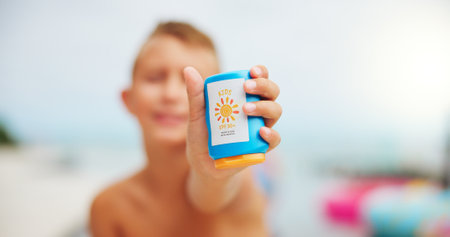 Sunscreen, hands and bottle with child at swimming pool for uv rays protection, spf cream and summer vacation. Sunblock lotion, dermatology product and closeup with kid at holiday resort for skincareの写真素材
