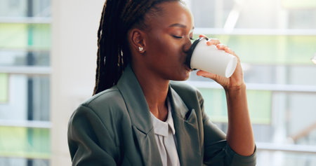 Black woman, drink and coffee with morning at office desk for beverage, start or caffeine. Female person, business employee or sip with plastic cup for latte, cappuccino or espresso at workplaceの写真素材