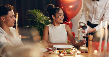 Couple, waiter and red wine on date at restaurant for valentines day, romantic dinner and...