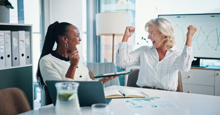 Business women, tablet and celebrate success, teamwork and excited for achievement in office. Winning, manager and cheers together with financial metrics, victory and target for investment growthの写真素材