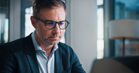 Business, man and glasses with laptop in office for finance report, proposal feedback and...