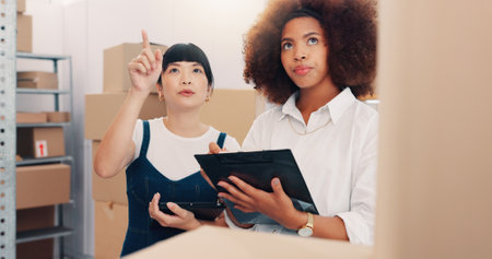 Team, logistics and business women check stock for inventory count or cargo management on tablet. Distribution, planning and supply chain for shipping discussion, ecommerce or clipboard in warehouseの写真素材