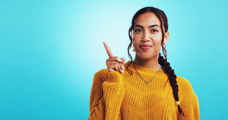 Portrait, woman and pointing with mockup space for deal, information and choice on blue background....