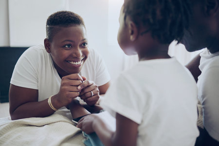 Black family, relax and bonding in home, happy mom and support with tablet entertainment on bed. Love, parents and daughter together for security in relationship, care and bedroom for connectionの写真素材
