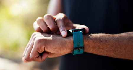 Fitness, hands and person check smart watch outdoor for cardio performance, running speed or tracking pulse. Athlete, runner and app for exercise progress, reading heart rate or steps count in natureの写真素材