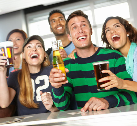 Support, fans and excited people in pub with alcohol, team and social celebration of football competition and score. Group, soccer game and fun friends in bar for party, beer and cheer at happy hourの写真素材