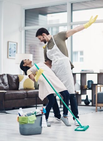 Cleaning, dance and couple with mop in home for hygiene, disinfection and bacteria. Marriage, detergents and playful man and woman with equipment for housekeeping, washing floor and tidy houseの写真素材