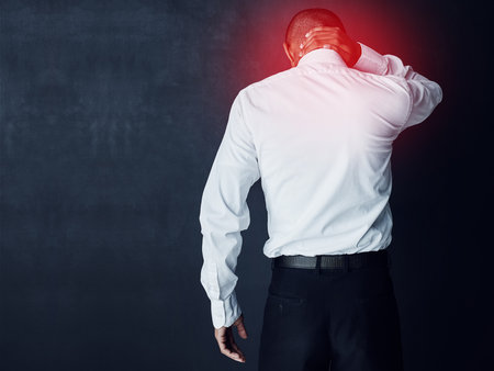 Hurt, studio and employee with neck pain, injury and person with muscle strain at work, tension and space. Black background, back and discomfort of inflammation, mockup and worker with bad postureの写真素材