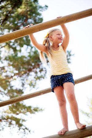Smile, girl and outdoor playground with equipment, adventure and playful exercise. Happy, child and...